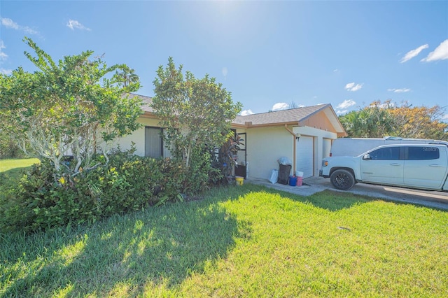 view of side of home with a yard and a garage