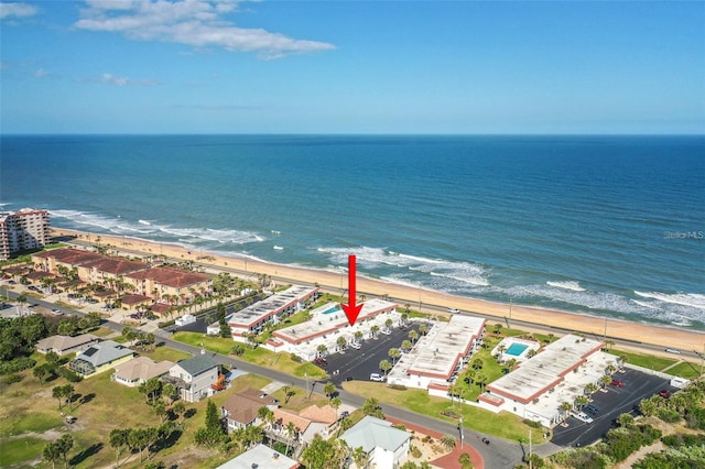 birds eye view of property with a water view and a beach view