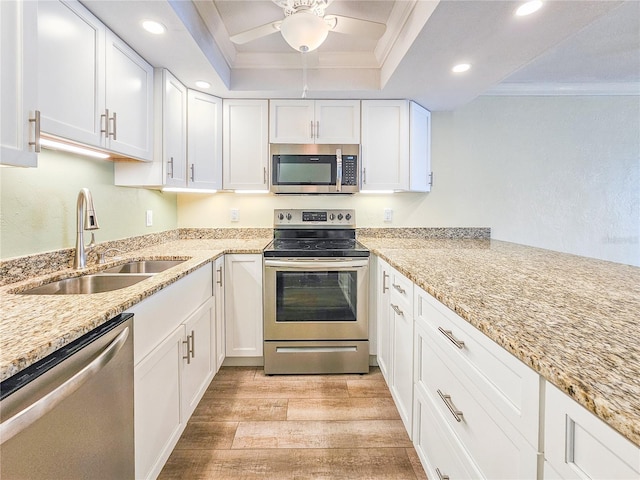 kitchen with crown molding, stainless steel appliances, sink, and white cabinets