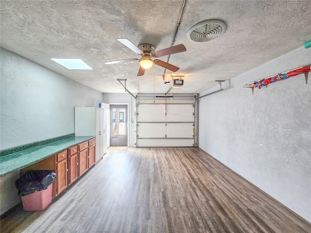 garage with a garage door opener and ceiling fan