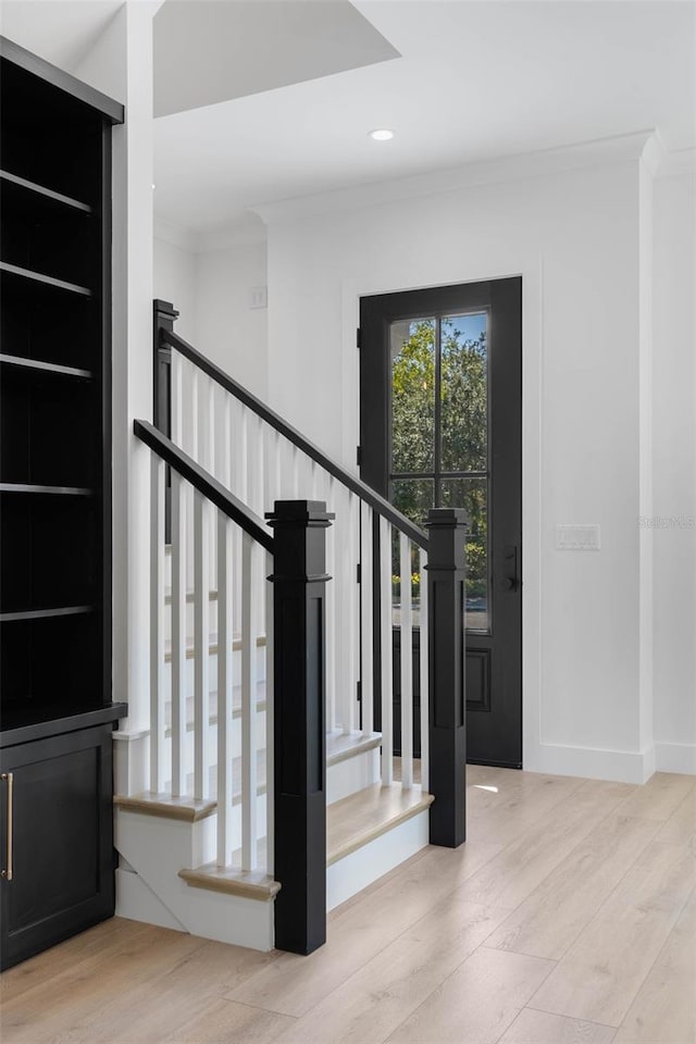 staircase with hardwood / wood-style flooring and crown molding