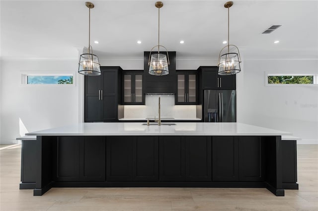 kitchen with stainless steel refrigerator with ice dispenser, a spacious island, and pendant lighting