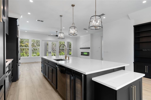 kitchen with crown molding, pendant lighting, a spacious island, sink, and a fireplace