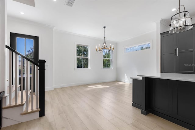 unfurnished dining area featuring light hardwood / wood-style floors, a chandelier, and ornamental molding