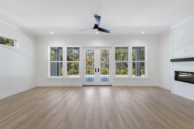 unfurnished living room with french doors, light wood-type flooring, ceiling fan, and ornamental molding