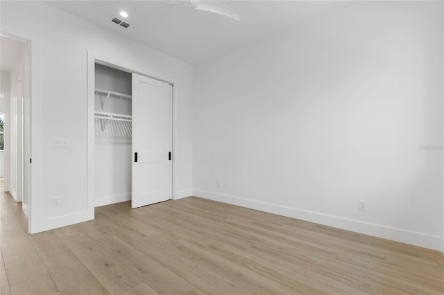 unfurnished bedroom with a closet and light hardwood / wood-style flooring