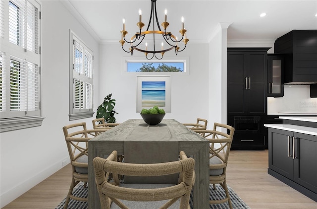 dining room featuring light hardwood / wood-style floors, crown molding, and an inviting chandelier