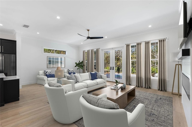 living room featuring ceiling fan, french doors, light hardwood / wood-style flooring, and crown molding