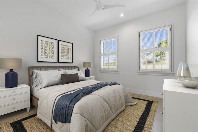 bedroom featuring ceiling fan, multiple windows, and wood-type flooring