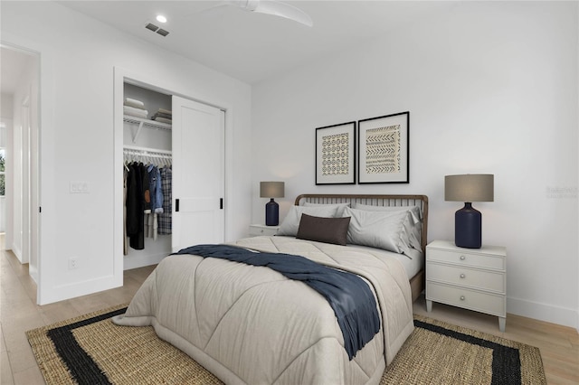 bedroom with light hardwood / wood-style floors and a closet