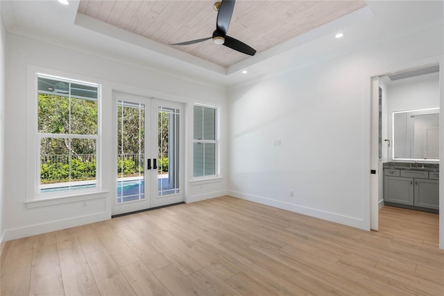 spare room with wood ceiling, light wood-type flooring, and a raised ceiling