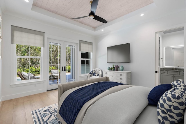 bedroom with ceiling fan, wooden ceiling, a tray ceiling, and ensuite bathroom