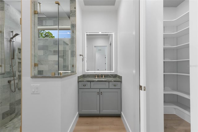 bathroom featuring a shower, wood-type flooring, and vanity