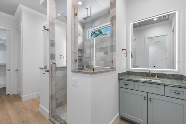 bathroom featuring vanity, hardwood / wood-style flooring, and walk in shower