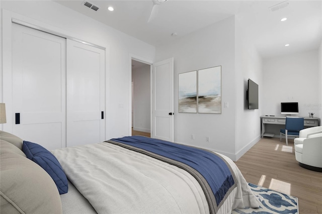 bedroom featuring light hardwood / wood-style floors, a closet, and ceiling fan