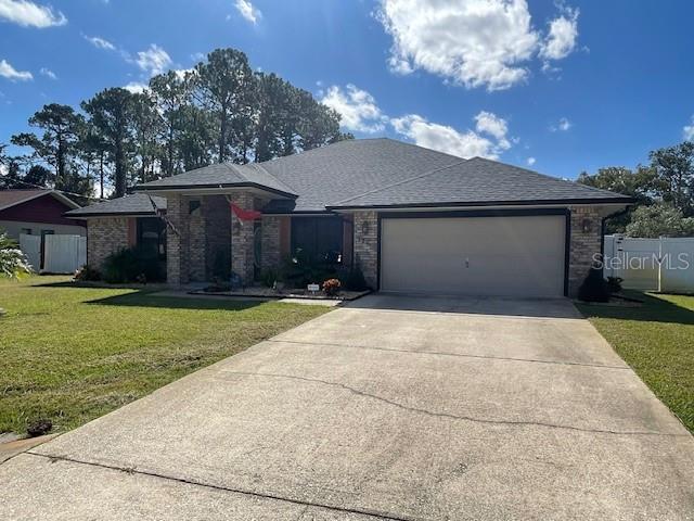 view of front of home with a front lawn and a garage