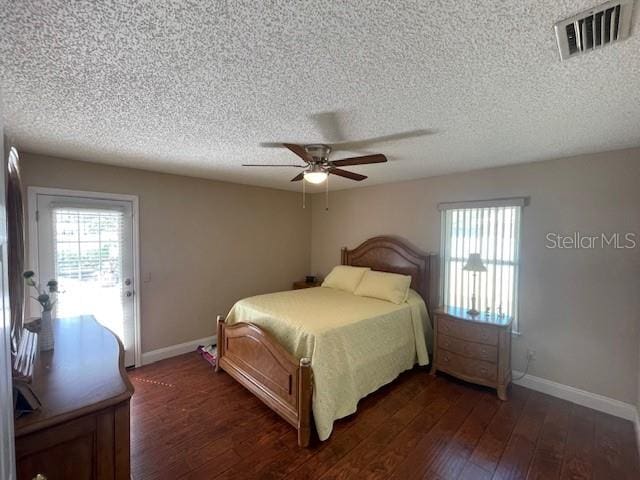 bedroom featuring dark hardwood / wood-style floors, a textured ceiling, and ceiling fan