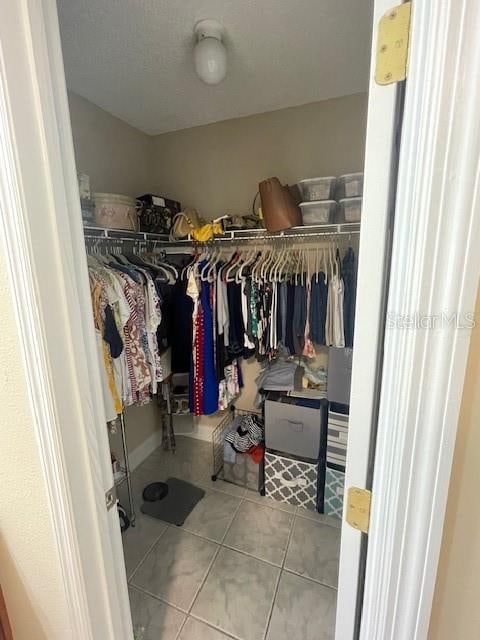 spacious closet with light tile patterned floors