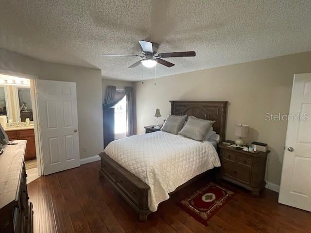 bedroom with ceiling fan, ensuite bath, a textured ceiling, and dark hardwood / wood-style floors