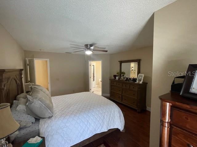 bedroom featuring dark hardwood / wood-style flooring, a textured ceiling, and ceiling fan