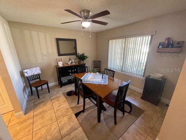 dining room featuring light tile patterned flooring, a textured ceiling, and ceiling fan