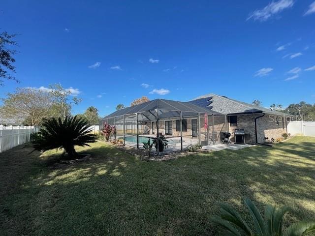 back of property featuring a patio, a fenced in pool, glass enclosure, and a lawn