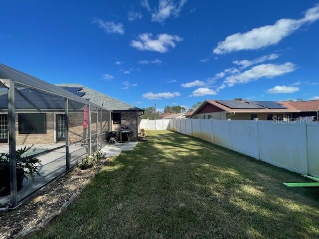 view of yard with a patio and glass enclosure