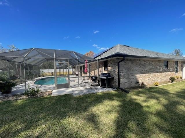 view of pool with a yard, a patio, and a lanai