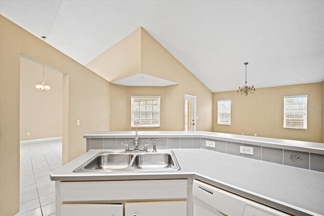 kitchen with lofted ceiling, light tile patterned floors, white cabinetry, dishwasher, and sink