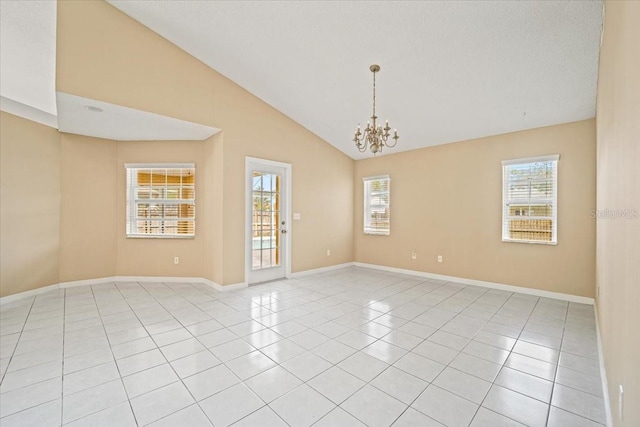 tiled spare room featuring a textured ceiling, a chandelier, high vaulted ceiling, and a wealth of natural light