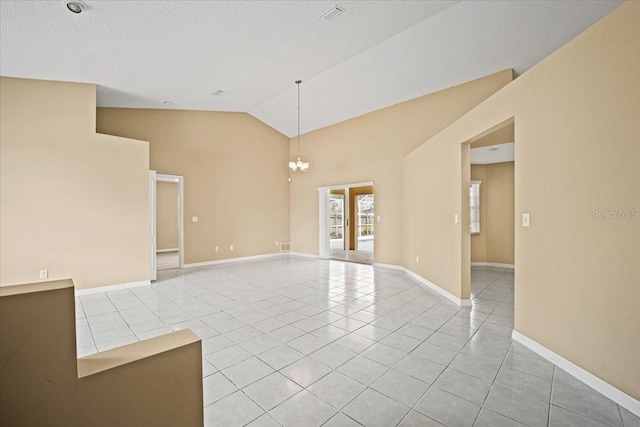 tiled spare room featuring a chandelier, a textured ceiling, and high vaulted ceiling