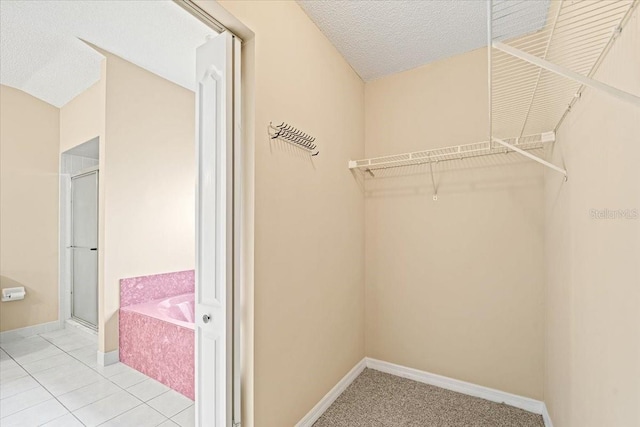 walk in closet with light tile patterned floors