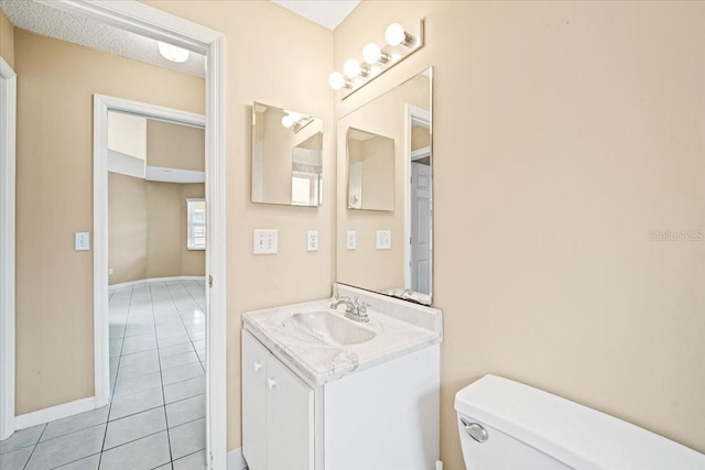 bathroom with toilet, vanity, and tile patterned flooring