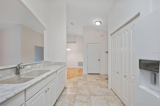 kitchen with light stone countertops, sink, dishwasher, white cabinetry, and lofted ceiling