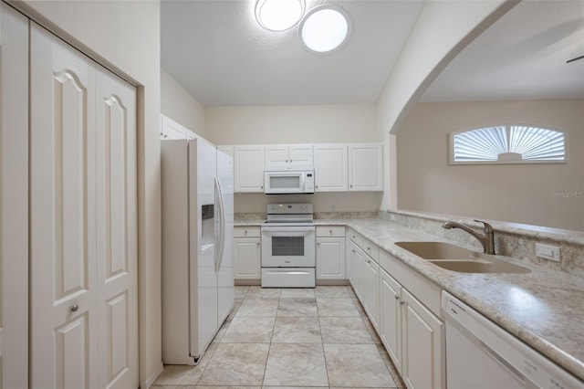 kitchen featuring white cabinetry, sink, and white appliances