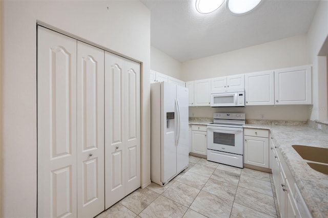 kitchen with white cabinets, a textured ceiling, light stone countertops, sink, and white appliances