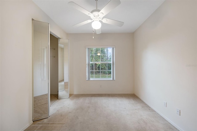 unfurnished bedroom with a closet, ceiling fan, and light colored carpet