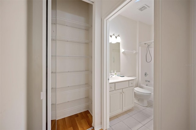 full bathroom featuring vanity, bathtub / shower combination, hardwood / wood-style floors, and toilet