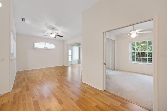 unfurnished room featuring a wealth of natural light, light hardwood / wood-style flooring, and ceiling fan