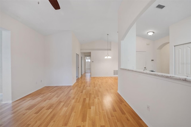 interior space featuring light hardwood / wood-style flooring, a notable chandelier, and vaulted ceiling