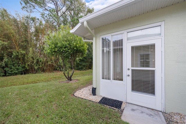 view of exterior entry featuring a yard