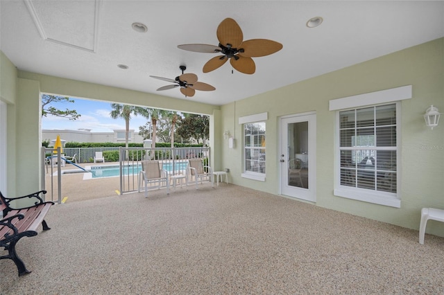 unfurnished sunroom featuring ceiling fan