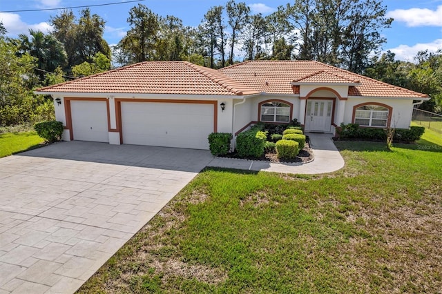 mediterranean / spanish home with a garage and a front lawn