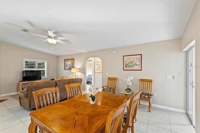 tiled dining area featuring ceiling fan and vaulted ceiling