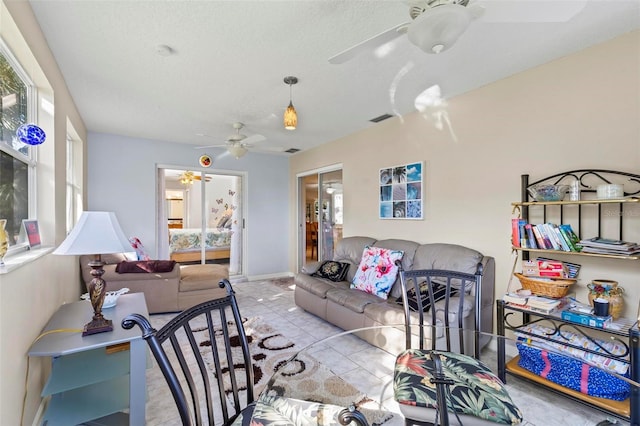 living room featuring ceiling fan and a textured ceiling