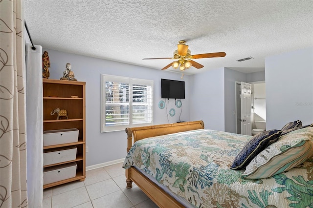 tiled bedroom featuring a textured ceiling, connected bathroom, and ceiling fan