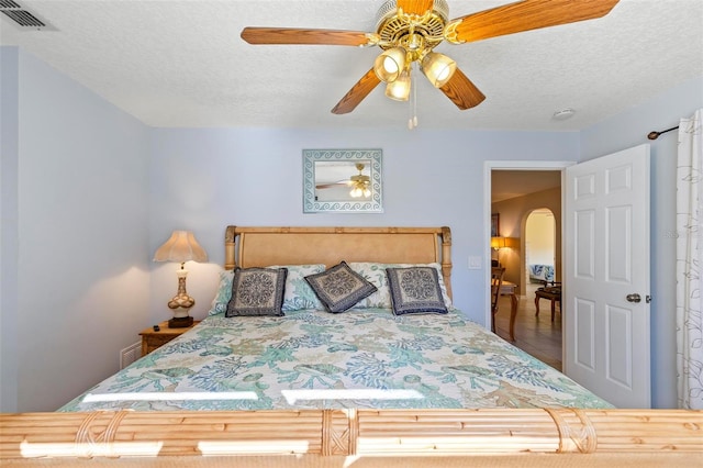 tiled bedroom with a textured ceiling and ceiling fan