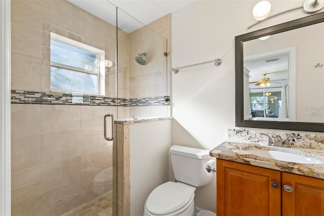 bathroom featuring vanity, a shower with shower door, toilet, and plenty of natural light