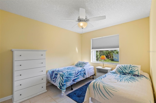 tiled bedroom with a textured ceiling and ceiling fan