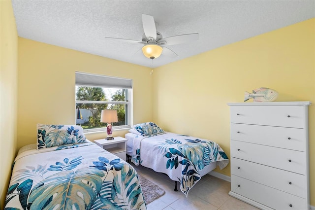 tiled bedroom featuring a textured ceiling and ceiling fan